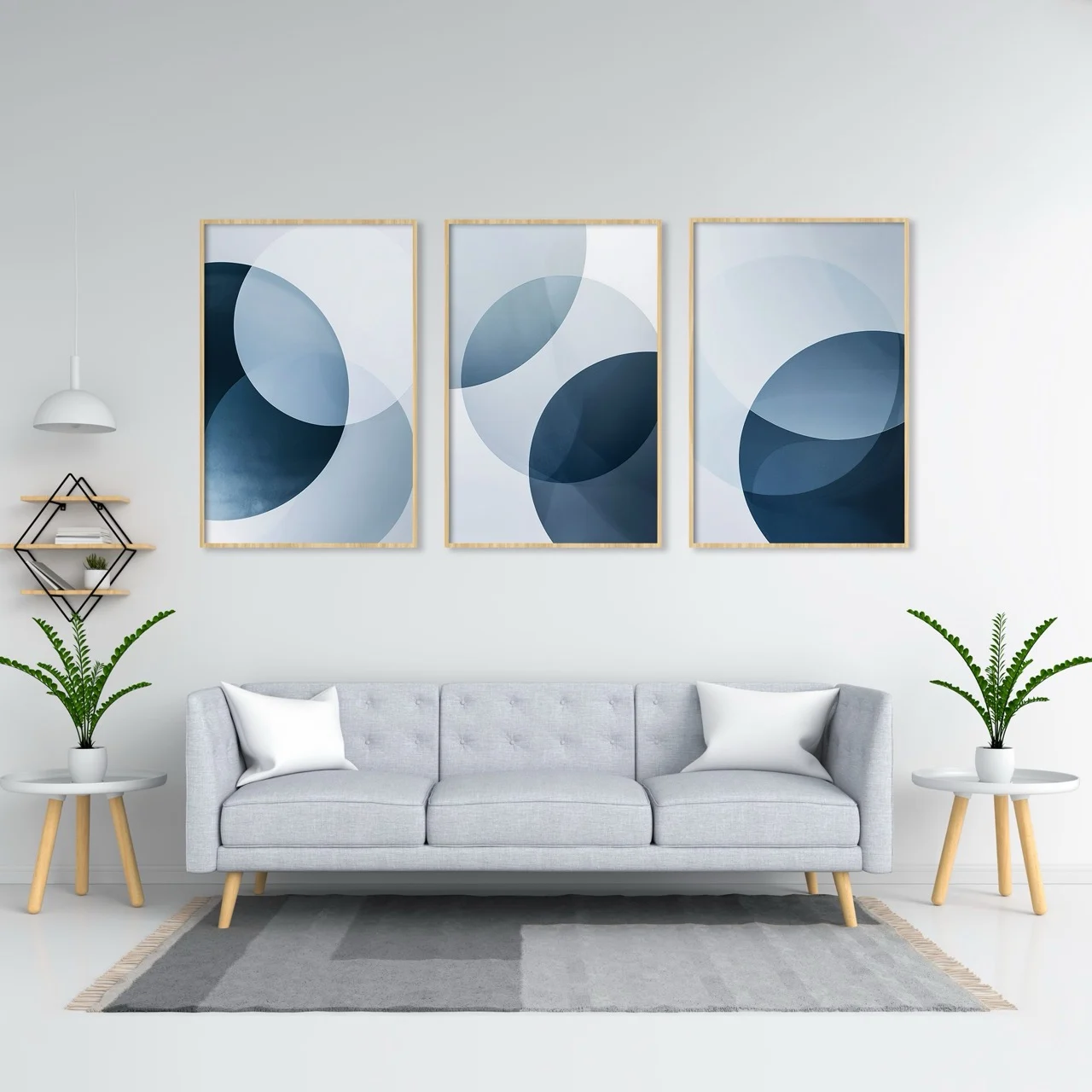 Three framed blue and white geometric abstract prints above a grey sofa in a bright living room.