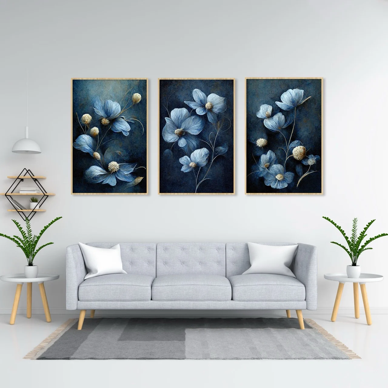 Three dark blue botanical prints with pale blue leaves above a grey sofa.